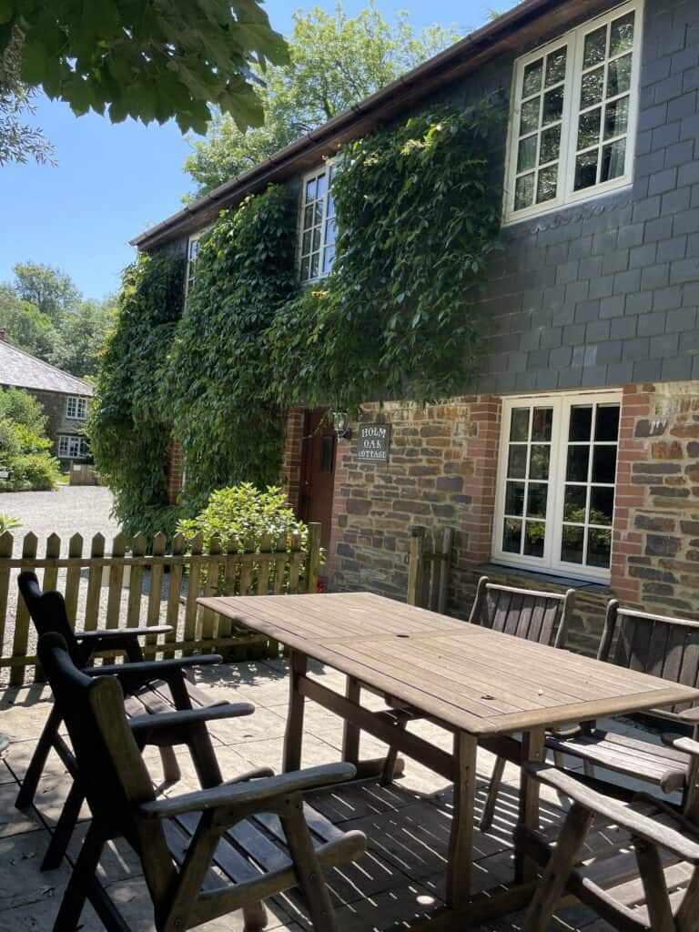 Traditional stone cottage patio with outdoor dining at Holm Oak Cottage near Looe, Cornwall